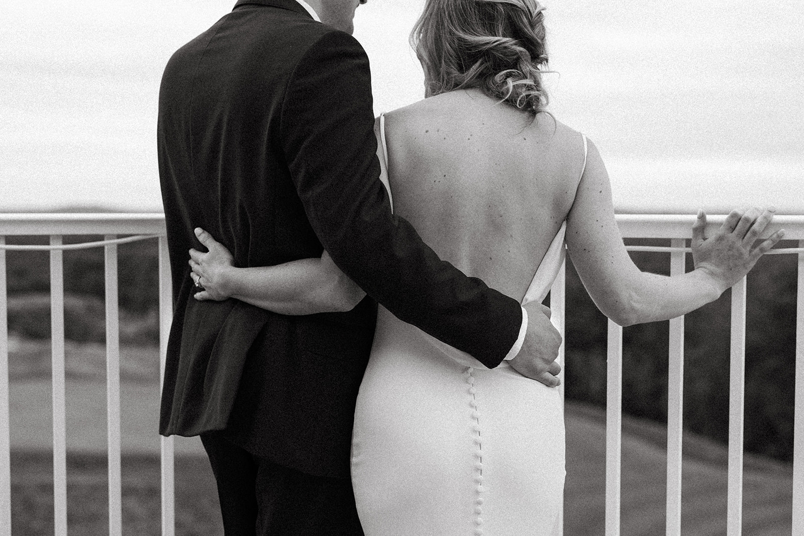 bride and groom standing on a balcony at Granite Links with a beautiful view