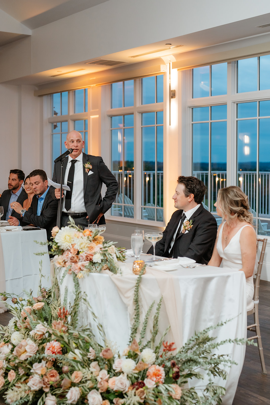 A happy couple at their wedding reception at Granite Links sitting together at a beautifully decorated table.