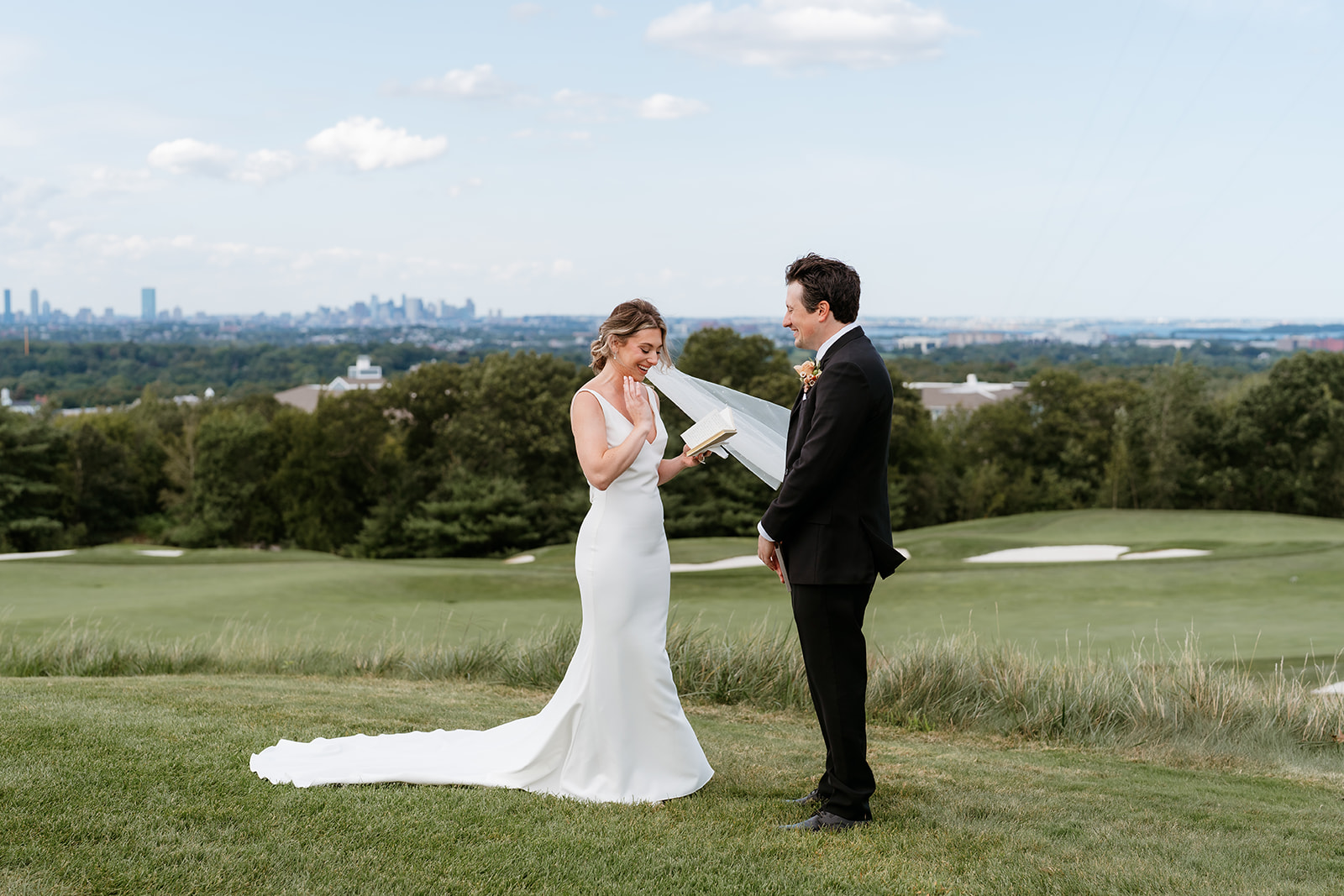 Bride and groom reading their vows to each other on a hill
