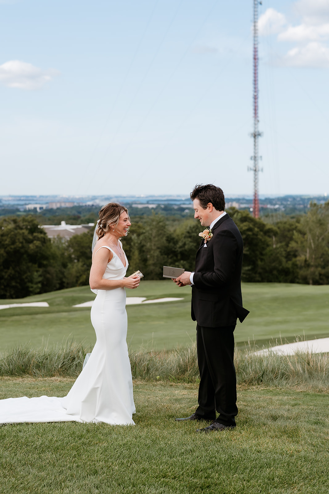 Bride and groom reading their vows to each other on a hill