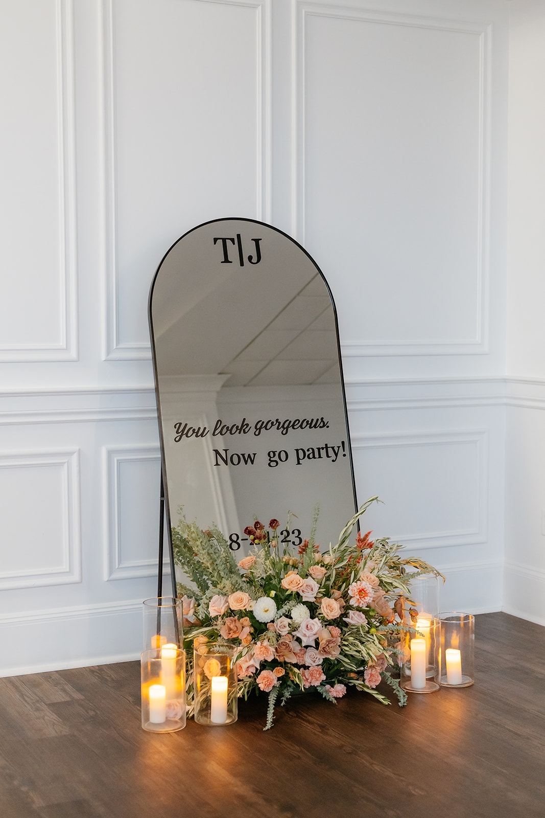 Flowers and candles reflecting in a mirror, creating a serene and romantic ambiance.