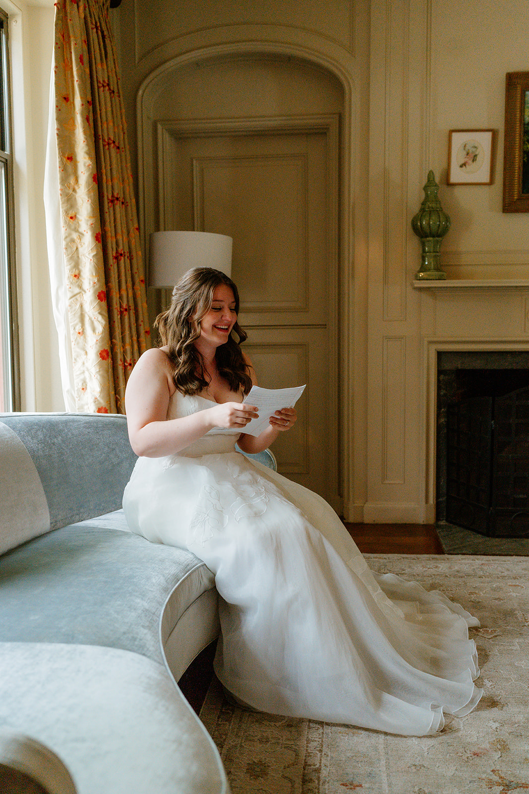 A woman in a dress reading a handwritten letter from her soon to be husband at The Estate at Moraine Farm