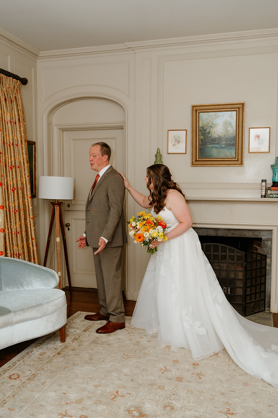 A bride and her father stand in a tastefully decorated room, sharing a moment before the wedding ceremony.