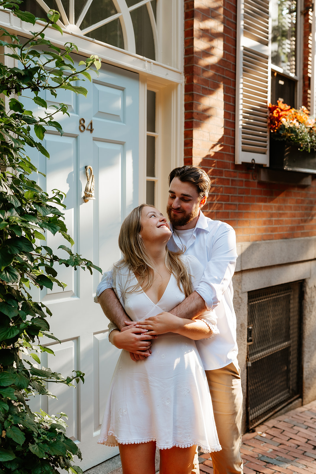 Couple holding one another smiling into eachothers eyes on the streets of Beacon Hill