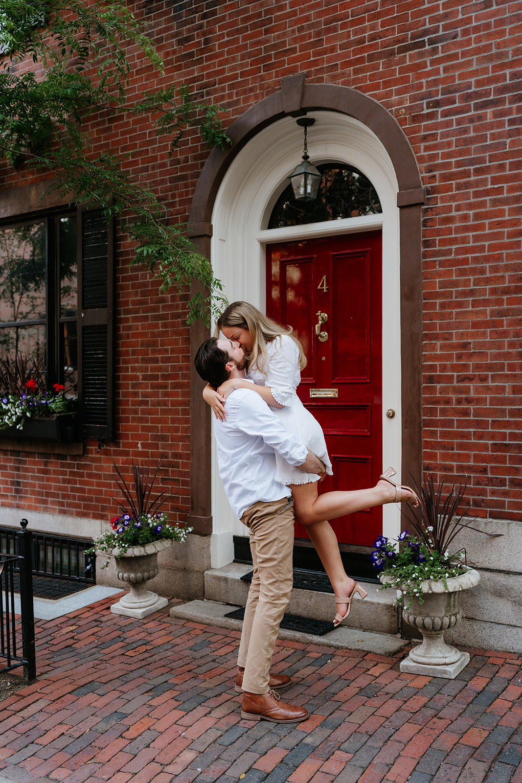 Couple kissing in front of a brick home in Boston at Beacon Hill