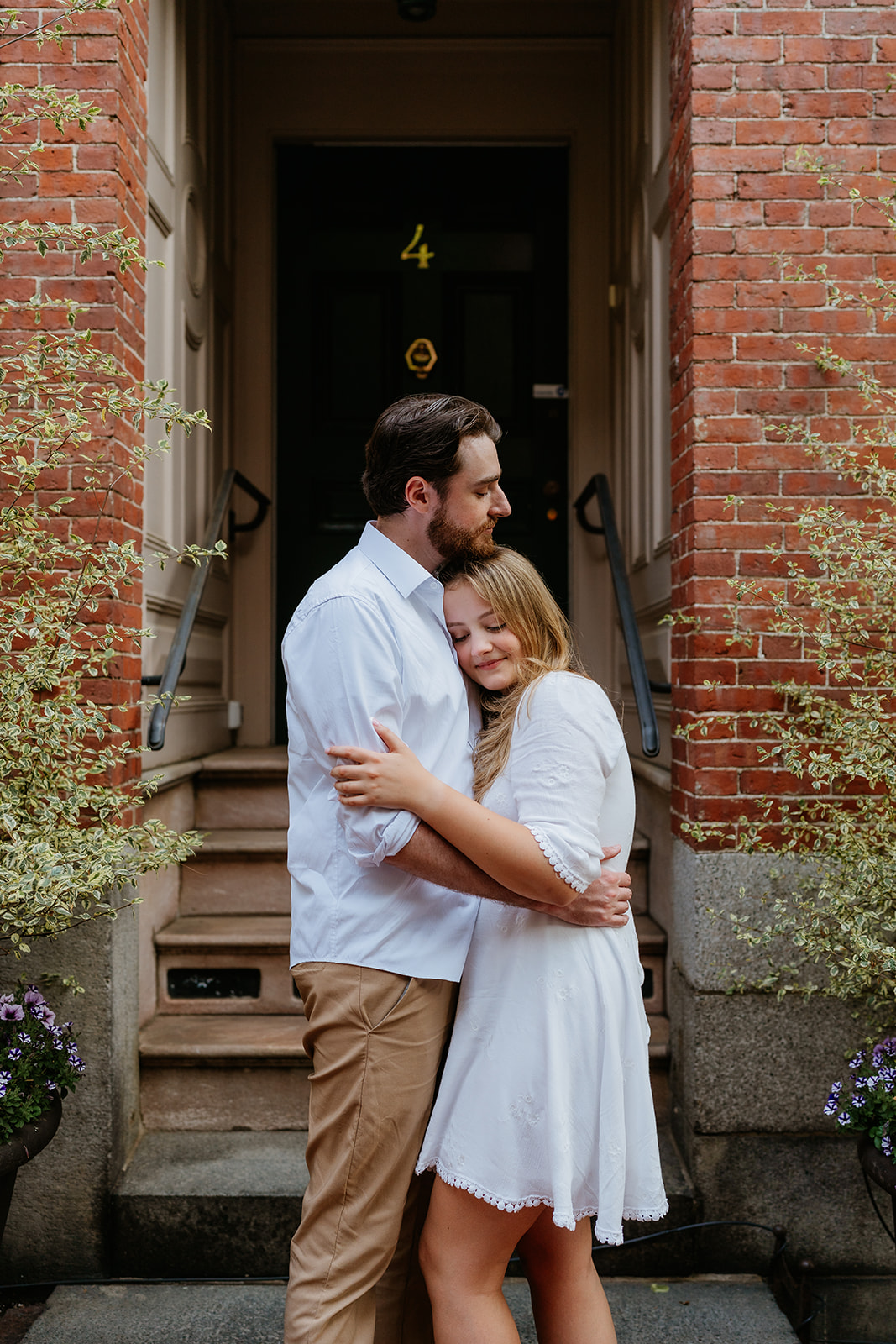 Couple hugging in front of a historical brick building