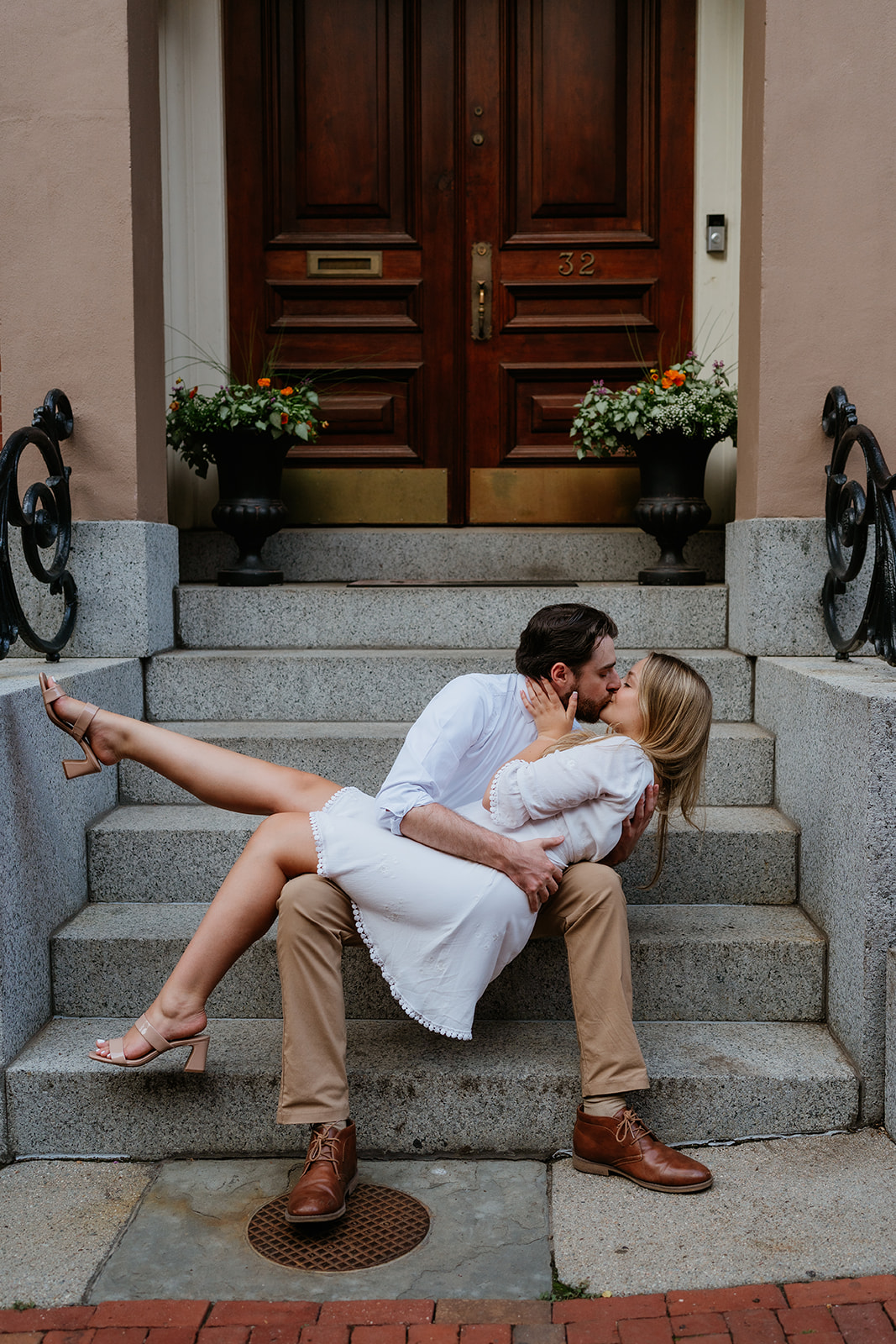 Couple kissing on the front door steps of a home in Boston