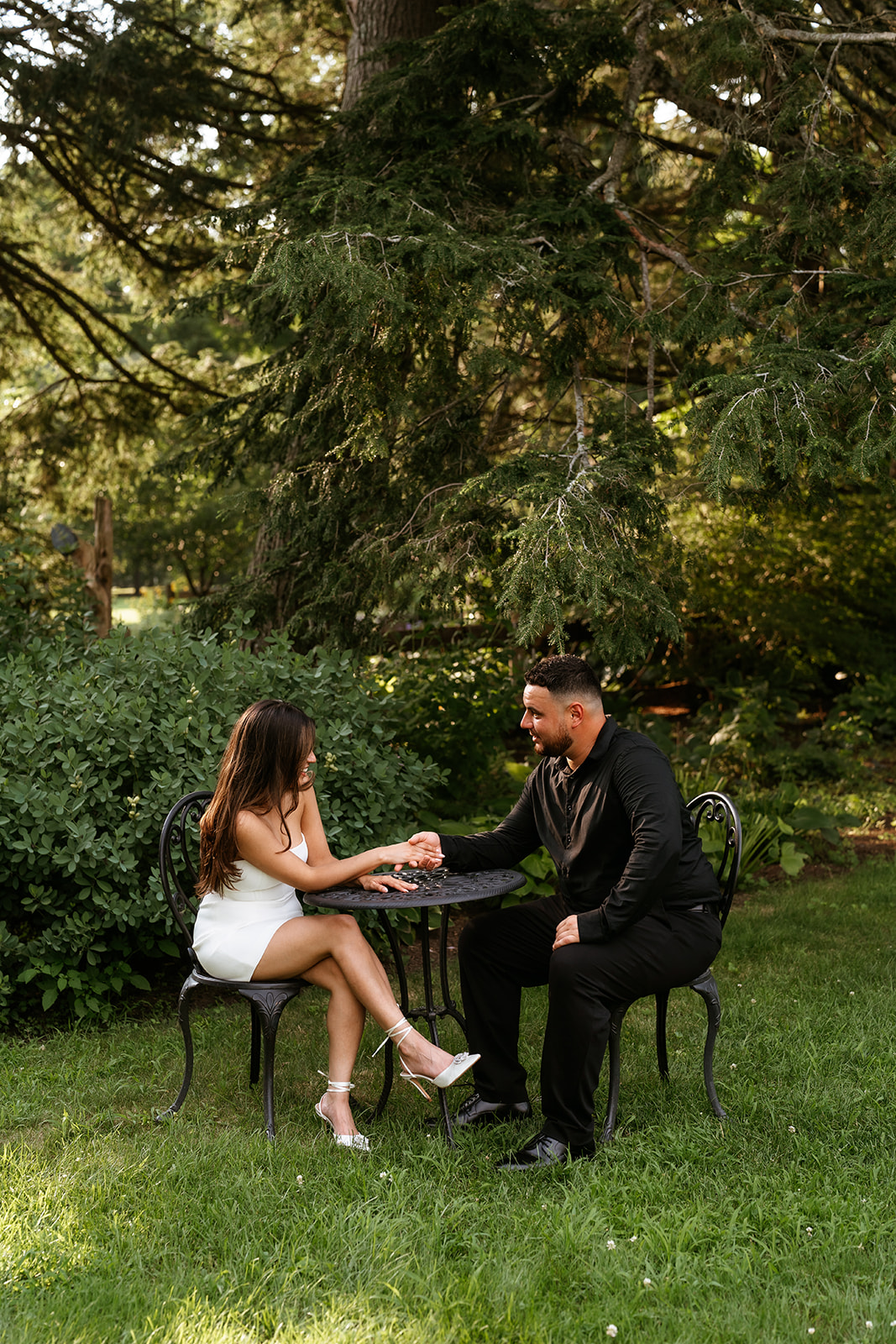 A man and woman at The Garden at Elm Bank holding hands during their engagement session