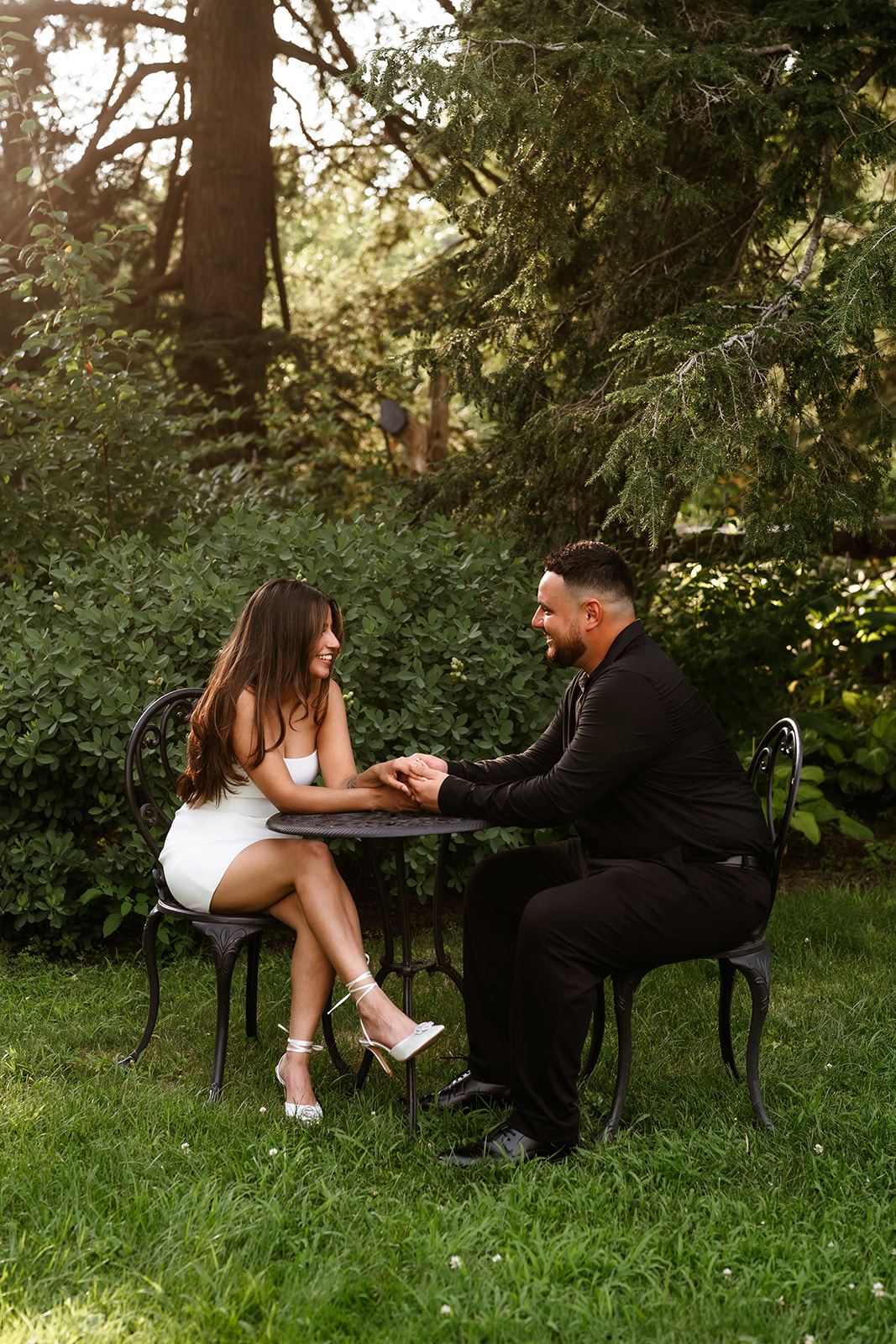 A man and woman at The Garden at Elm Bank holding hands during their engagement session