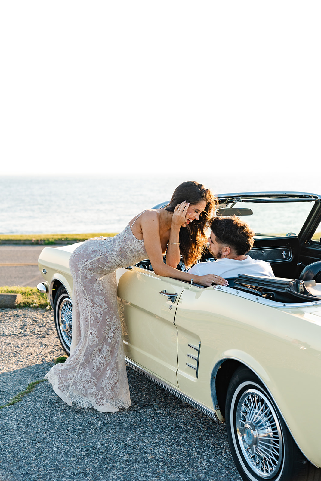 Newly engaged couple taking photos smiling for their classic car engagement photos