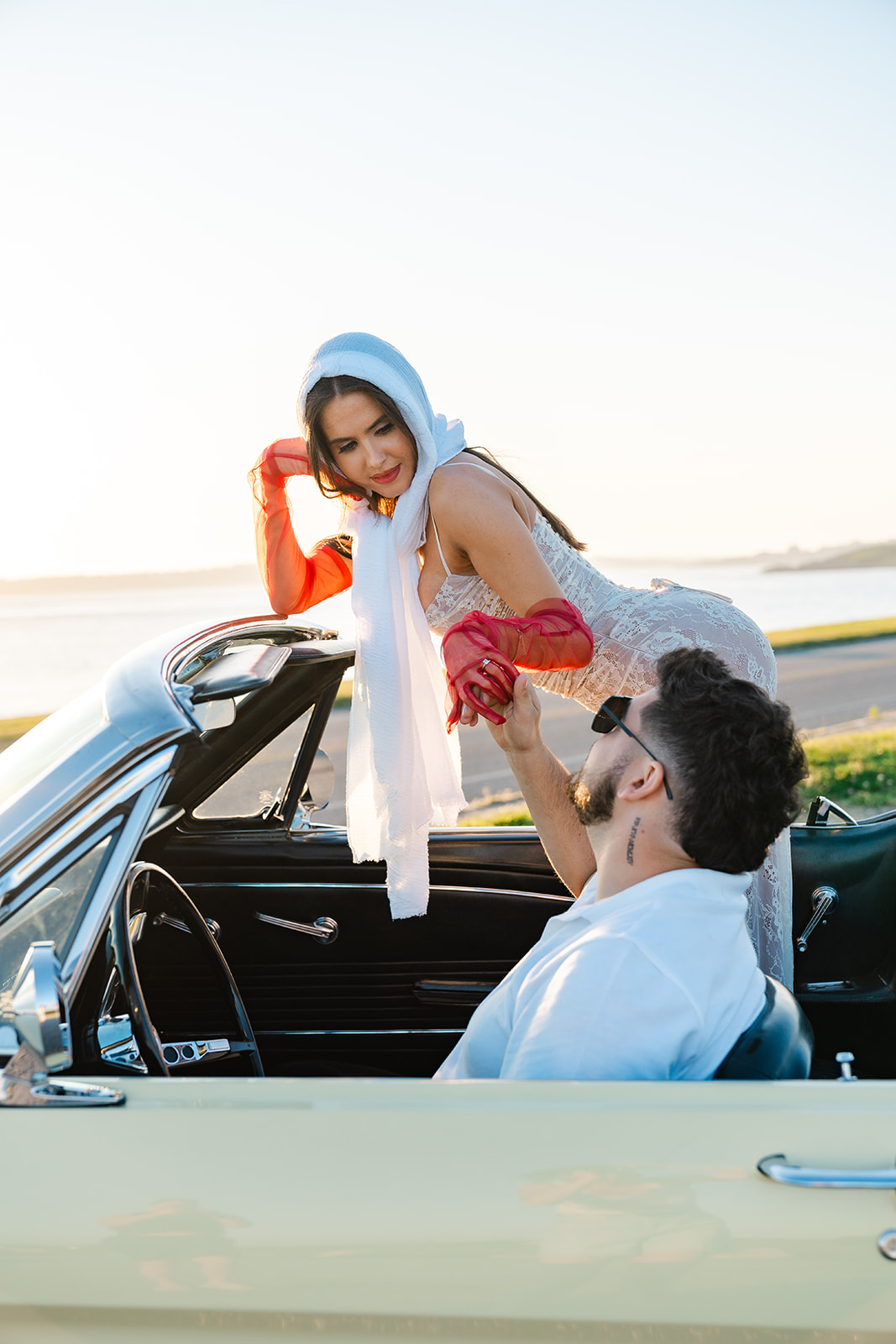 Newly engaged couple posing in a vintage car for their classic car engagement photos