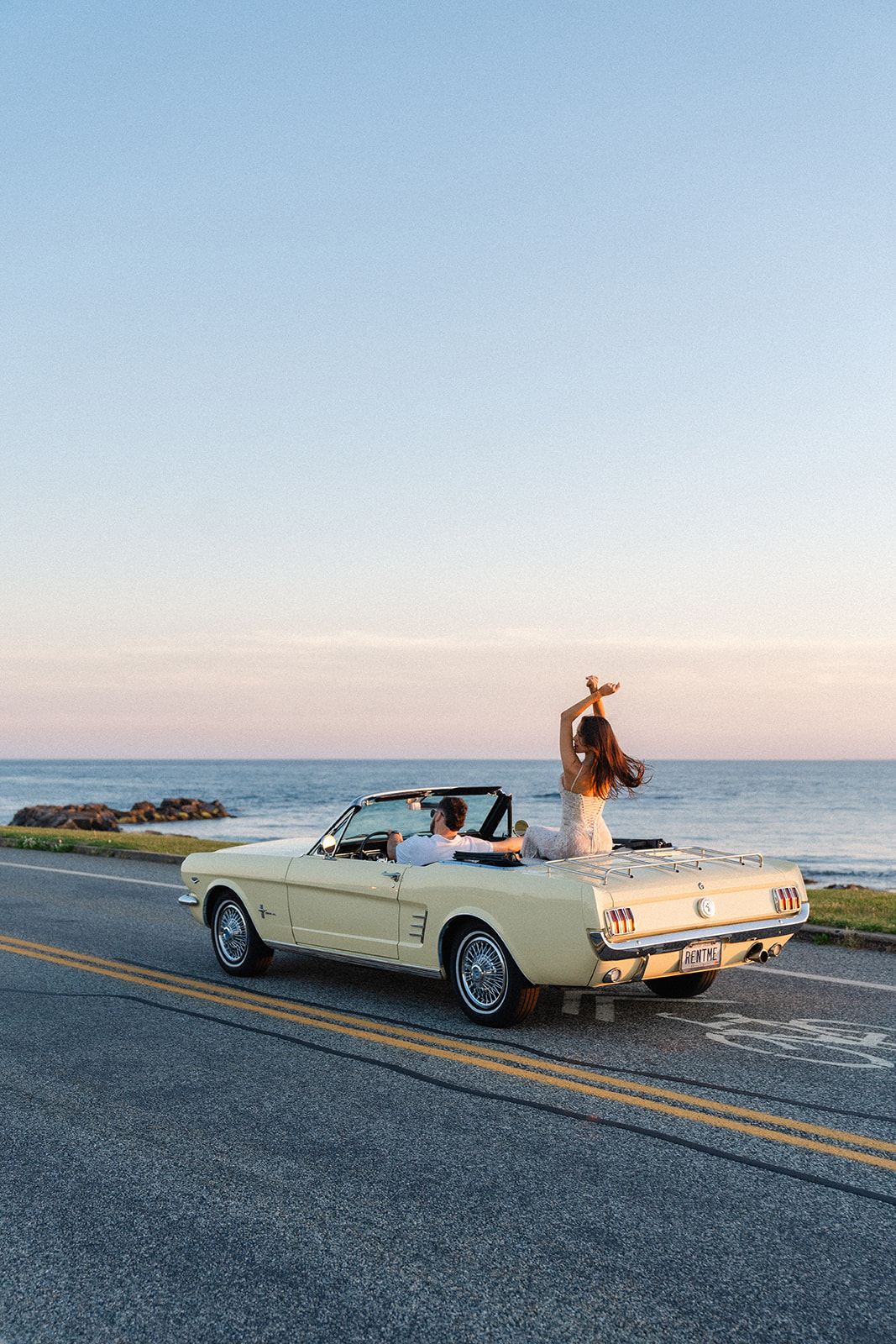 Newly engaged couple driving in a Vintage car on ocean drive for their classic car engagement photos