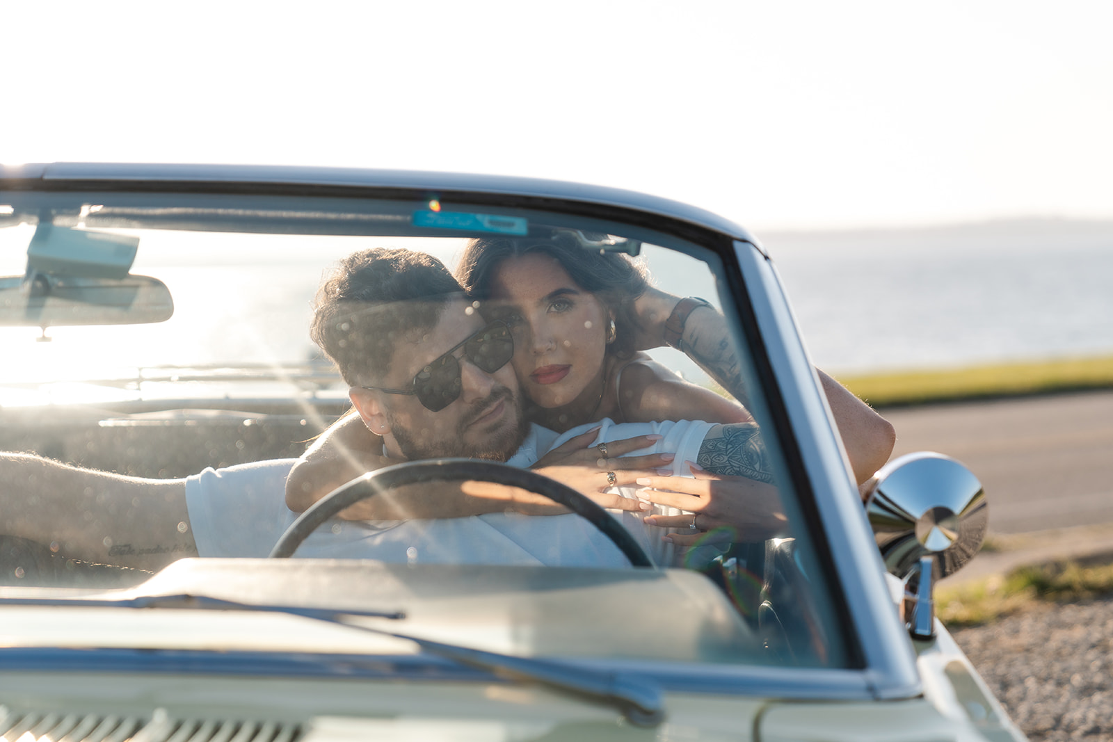 Newly engaged couple posing in a vintage car for their classic car engagement photos 