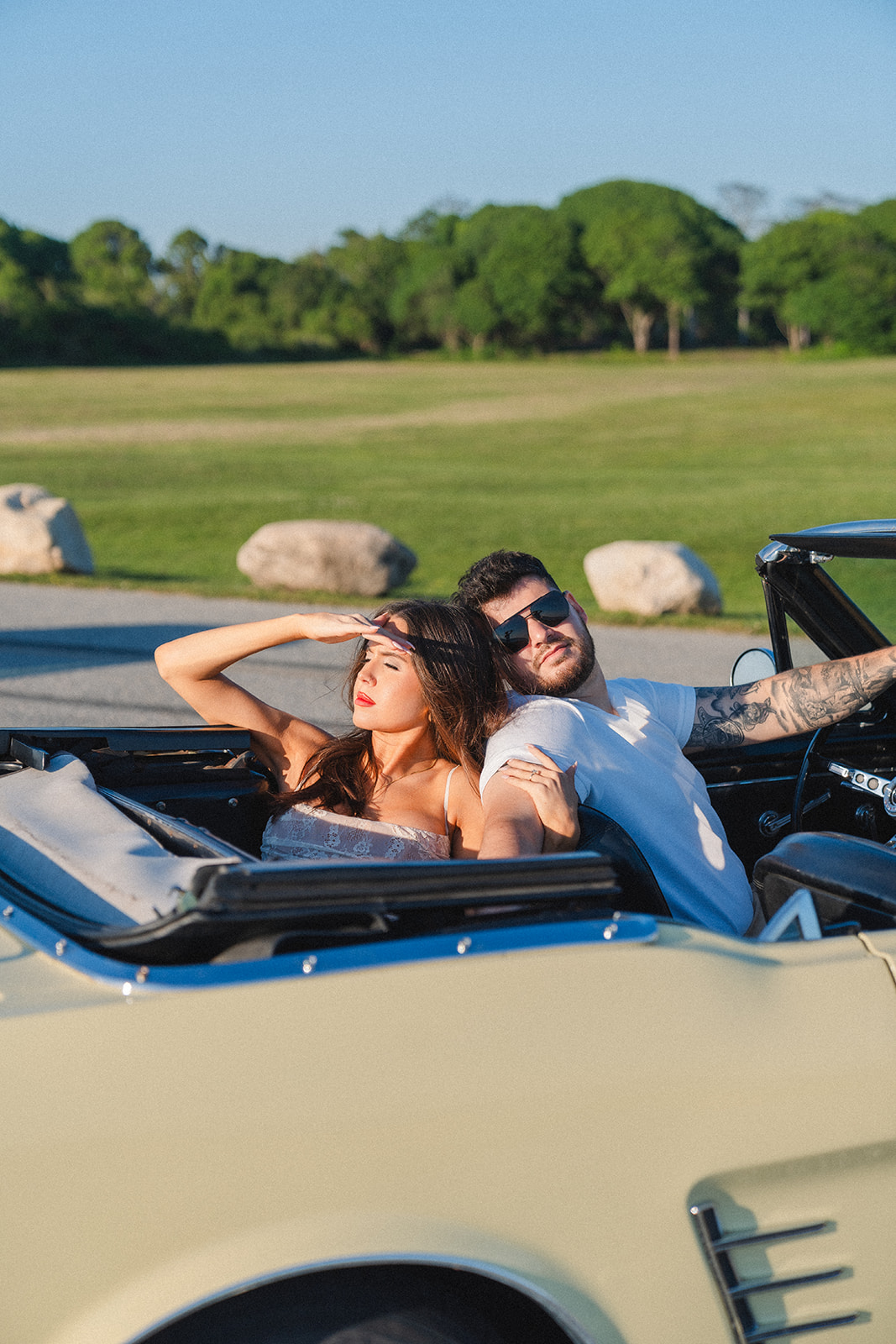 Newly engaged couple posing in a vintage car for their classic car engagement photos 