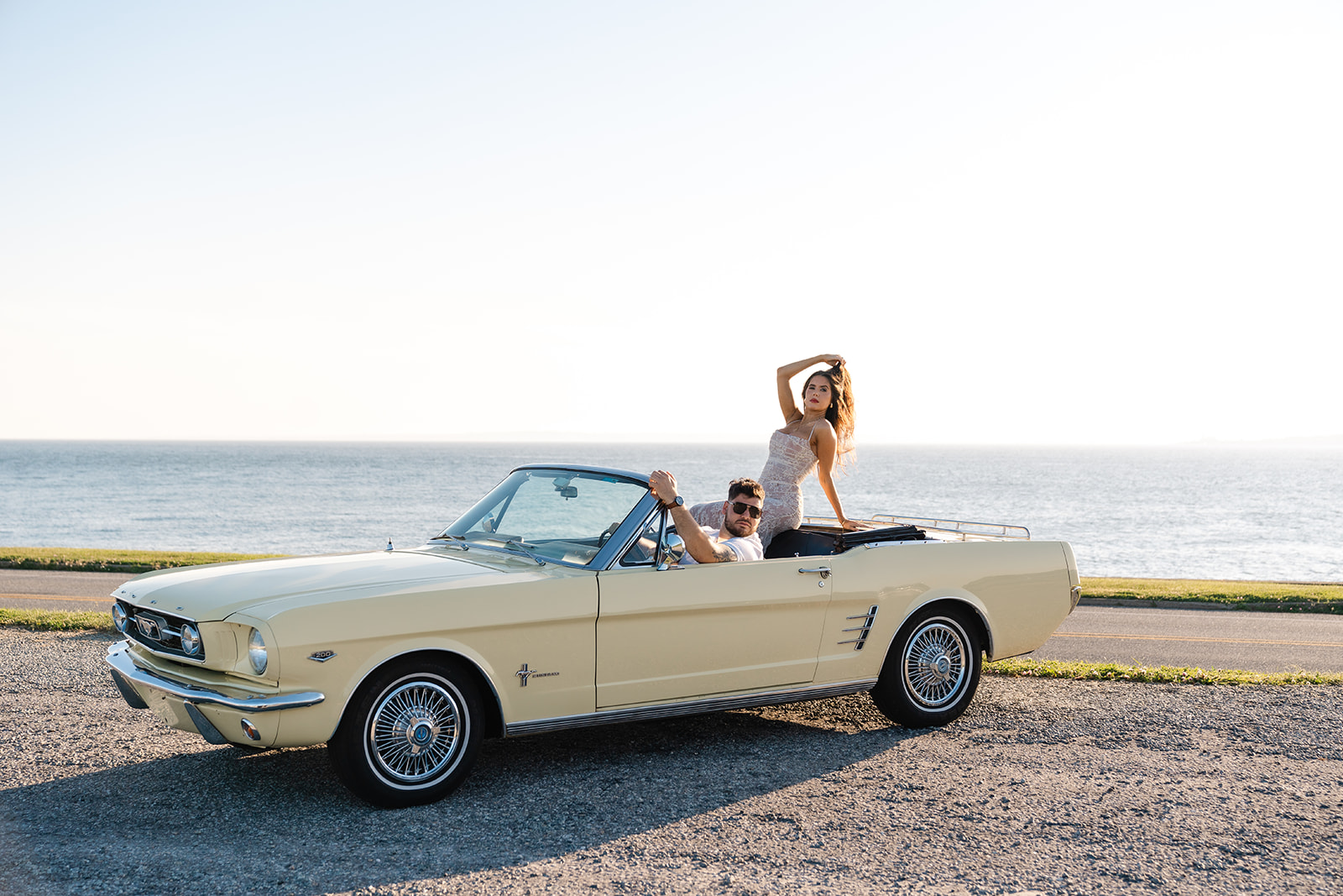 Newly engaged couple posing in a vintage car for their classic car engagement photos