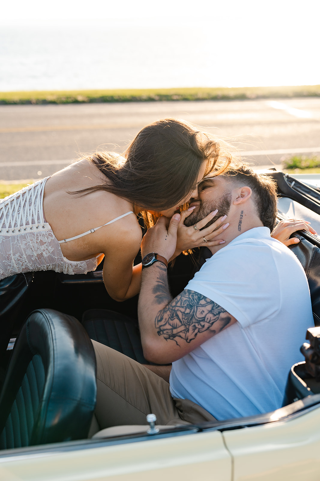 Newly engaged couple kissing in a vintage car for their classic car engagement photos 