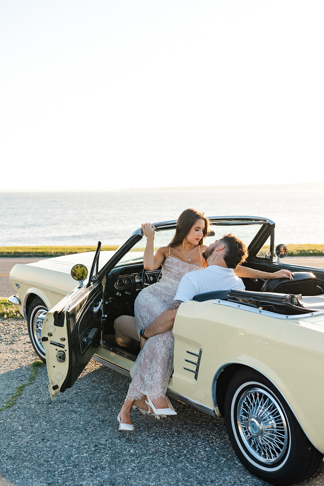 Newly engaged couple posing in a vintage car for their classic car engagement photos 