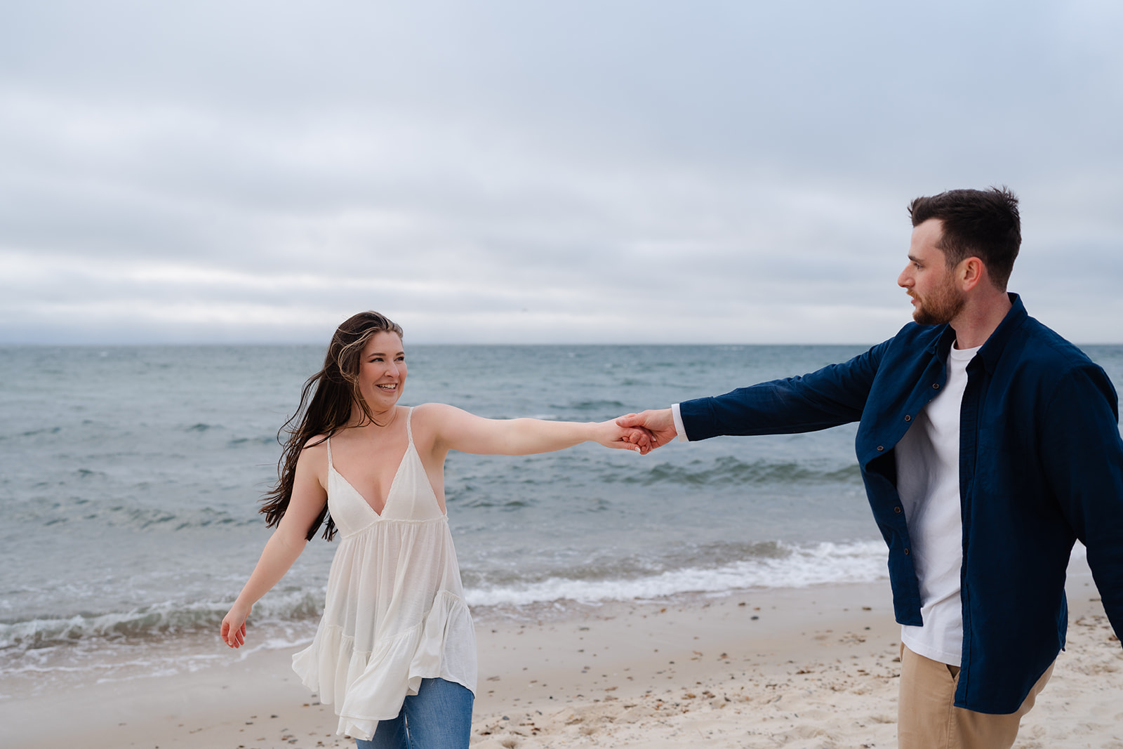 Engaged couple dancing on the beach in Cape Cod