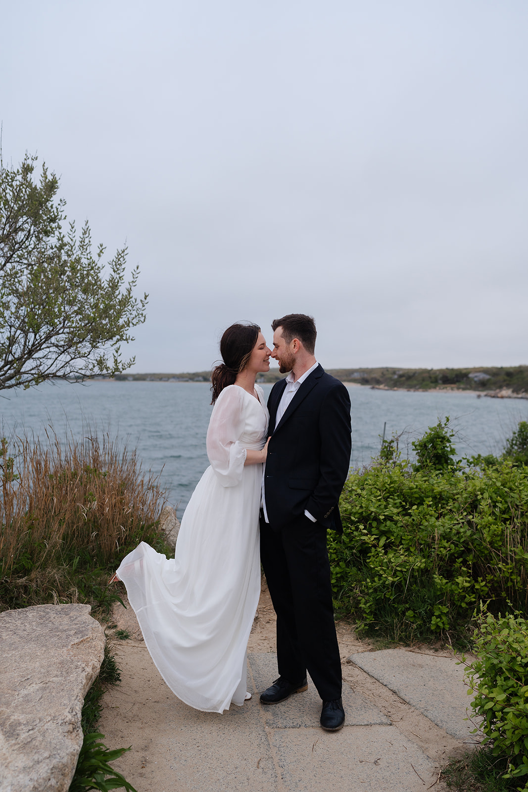 Engaged couple looking into eachothers eyes posing for their Cape Cod engagement photos