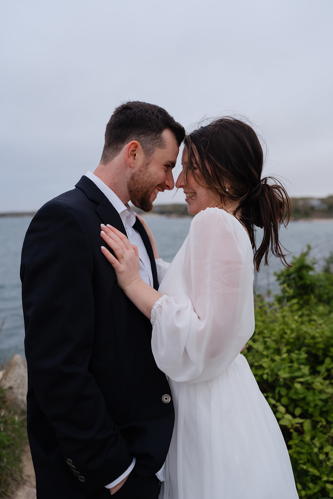 Engaged couple hugging and holding one another while smiling