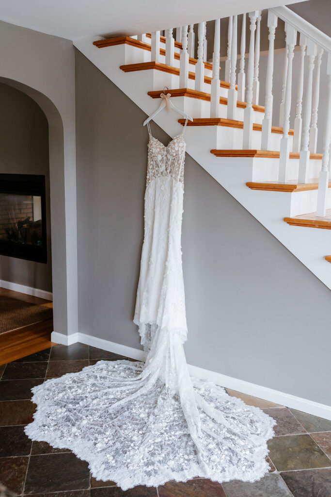 lace wedding dress hanging against the stairs