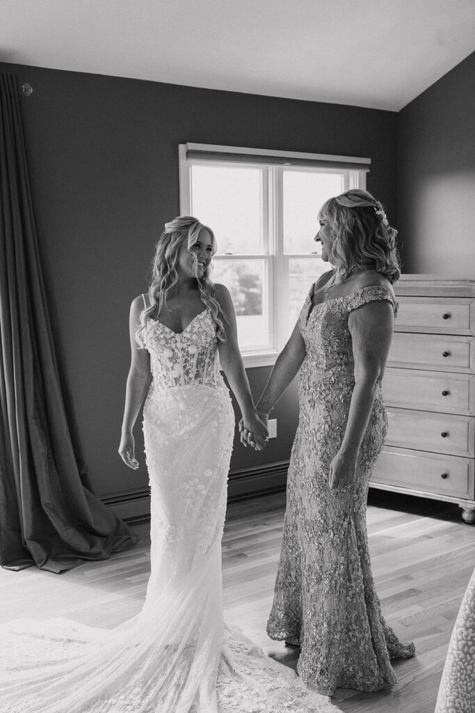 black and white photo of bride and her mother holding hands