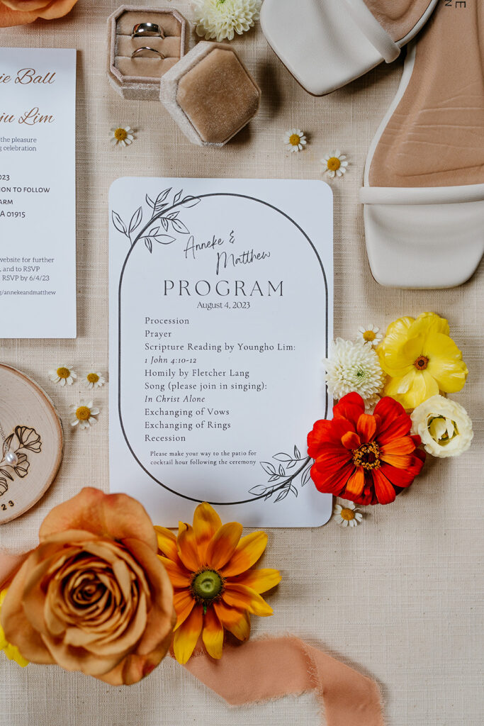 wedding details photo of the wedding program card with orange flowers