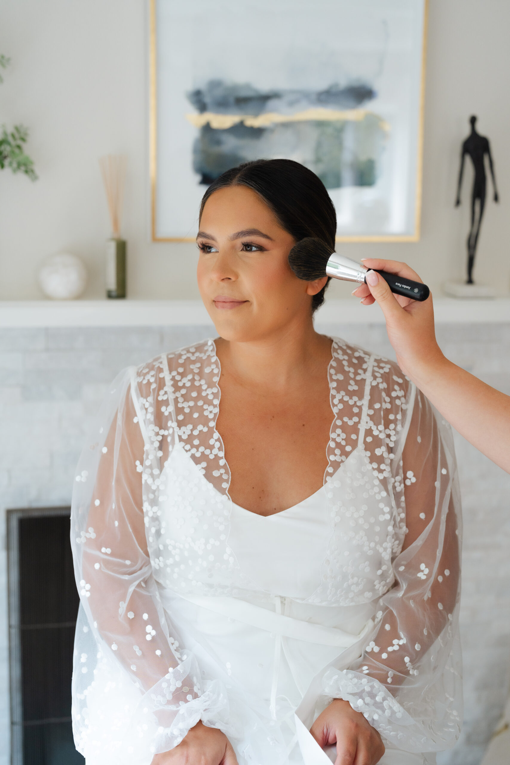 A candid wedding photo of the bride getting ready putting on her make up