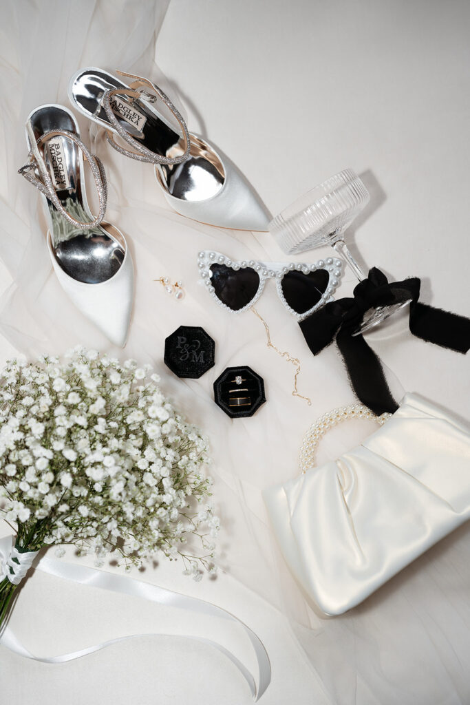 Modern wedding photo details with flash of bride's shoes, sunglasses, rings and wedding bag and bouquet