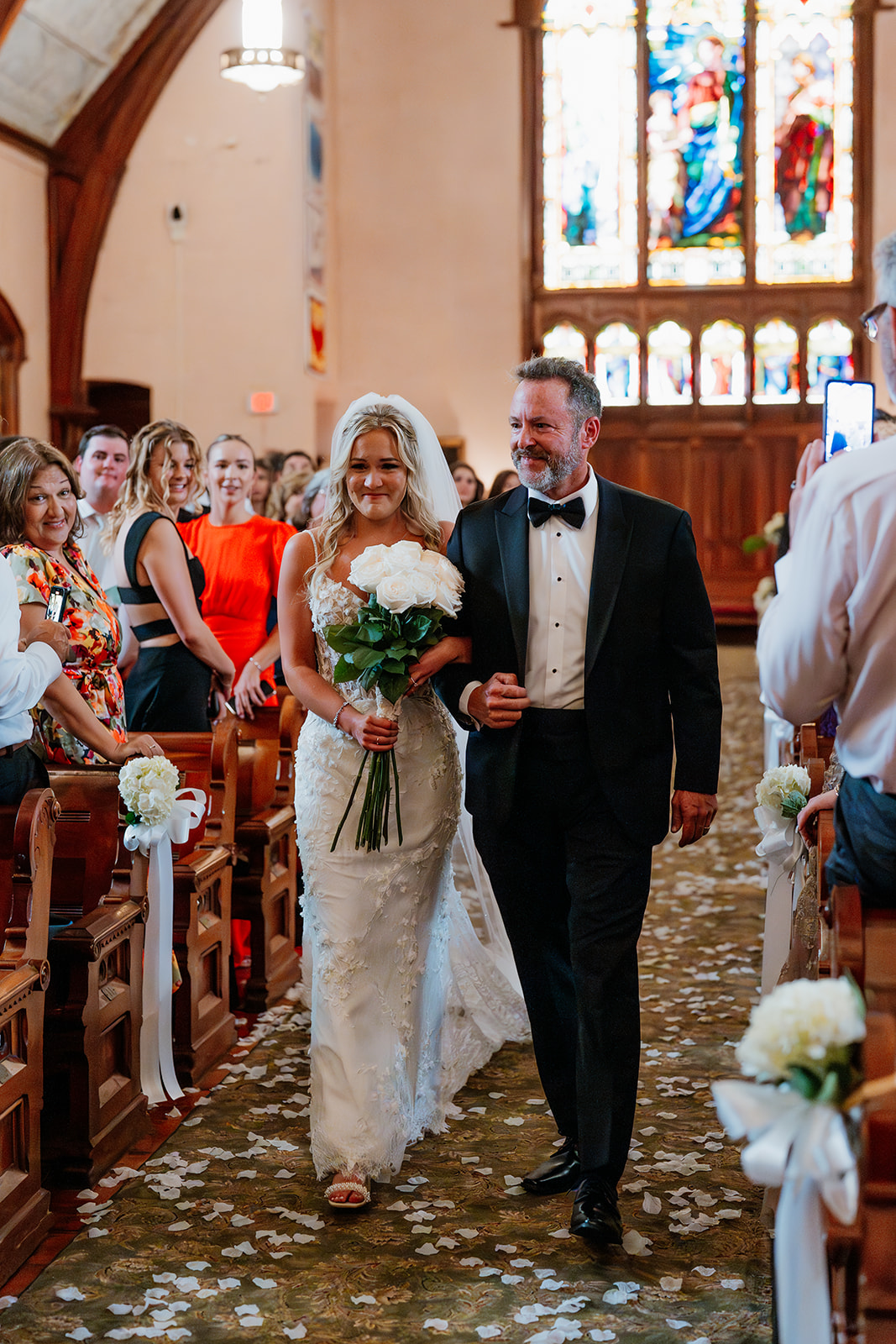 bride walking down the aisle with her father at a church