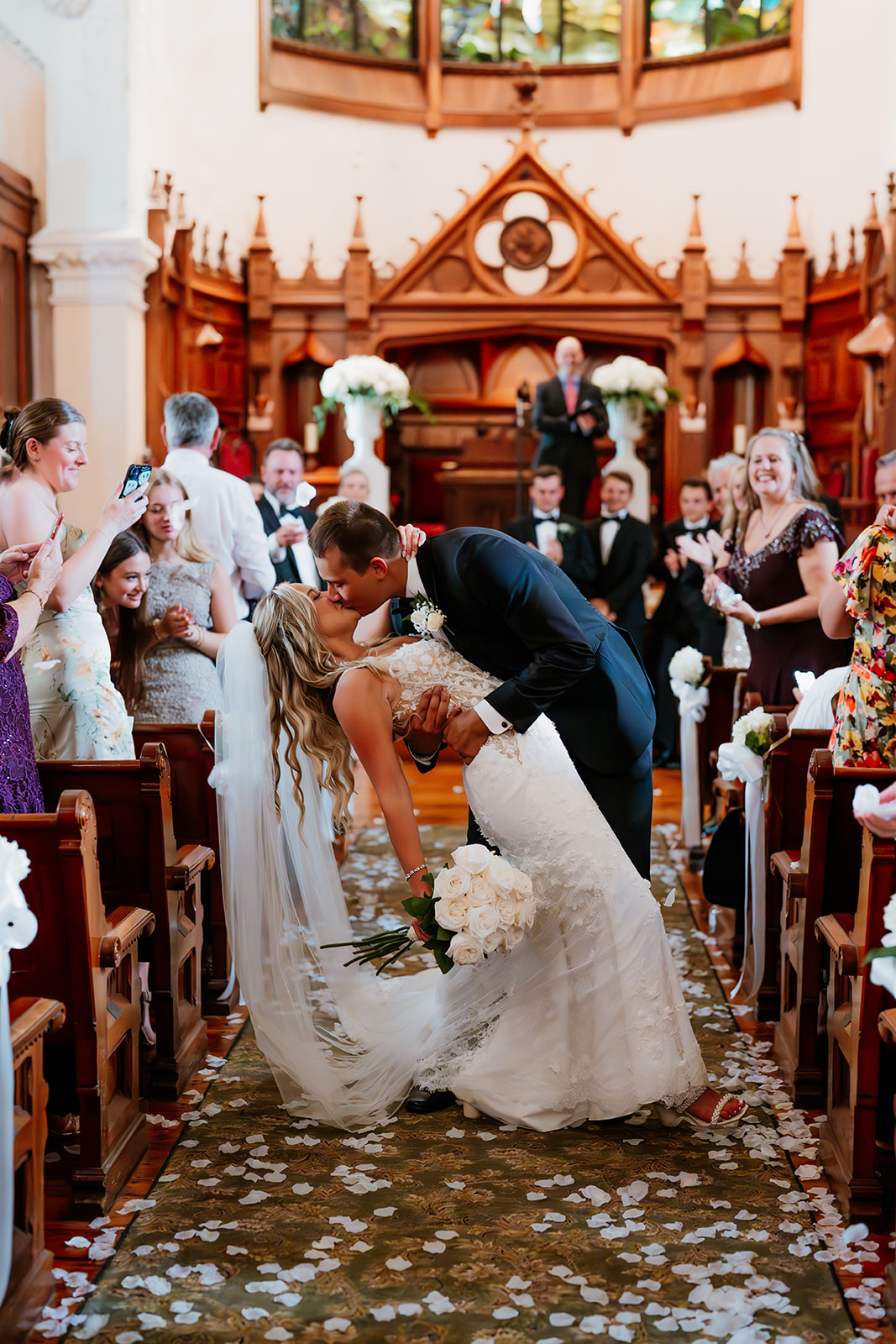 bride and groom kissing during wedding ceremony at a church in Newport