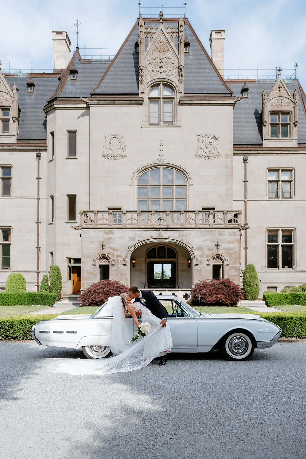 Bride and groom kissing in front of Ochre Court Building