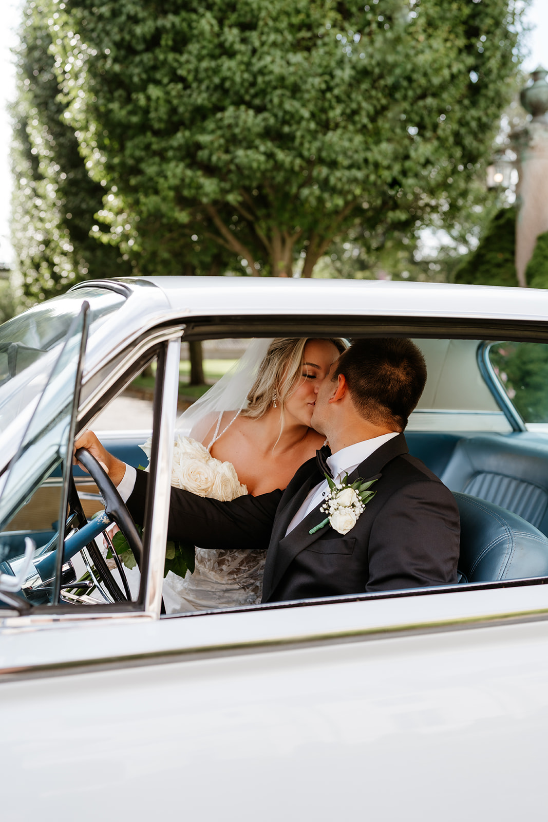 bride and groom kissing in a vintage car