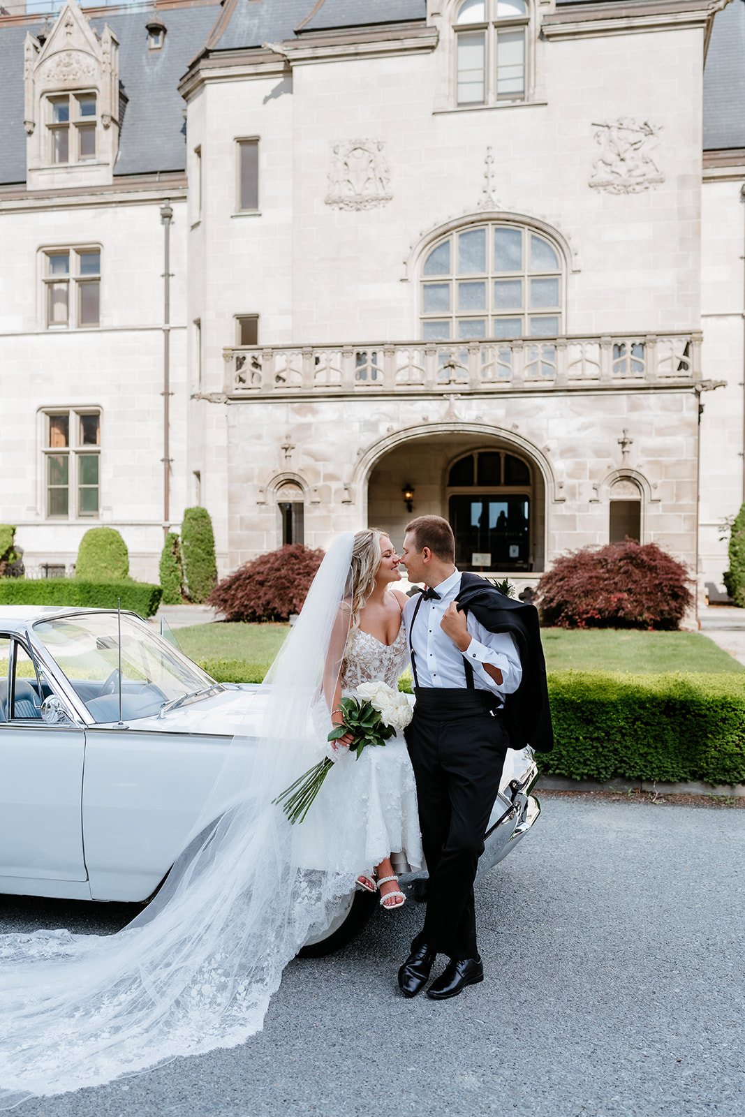 timeless wedding photo of bride and groom sitting on a vintage car