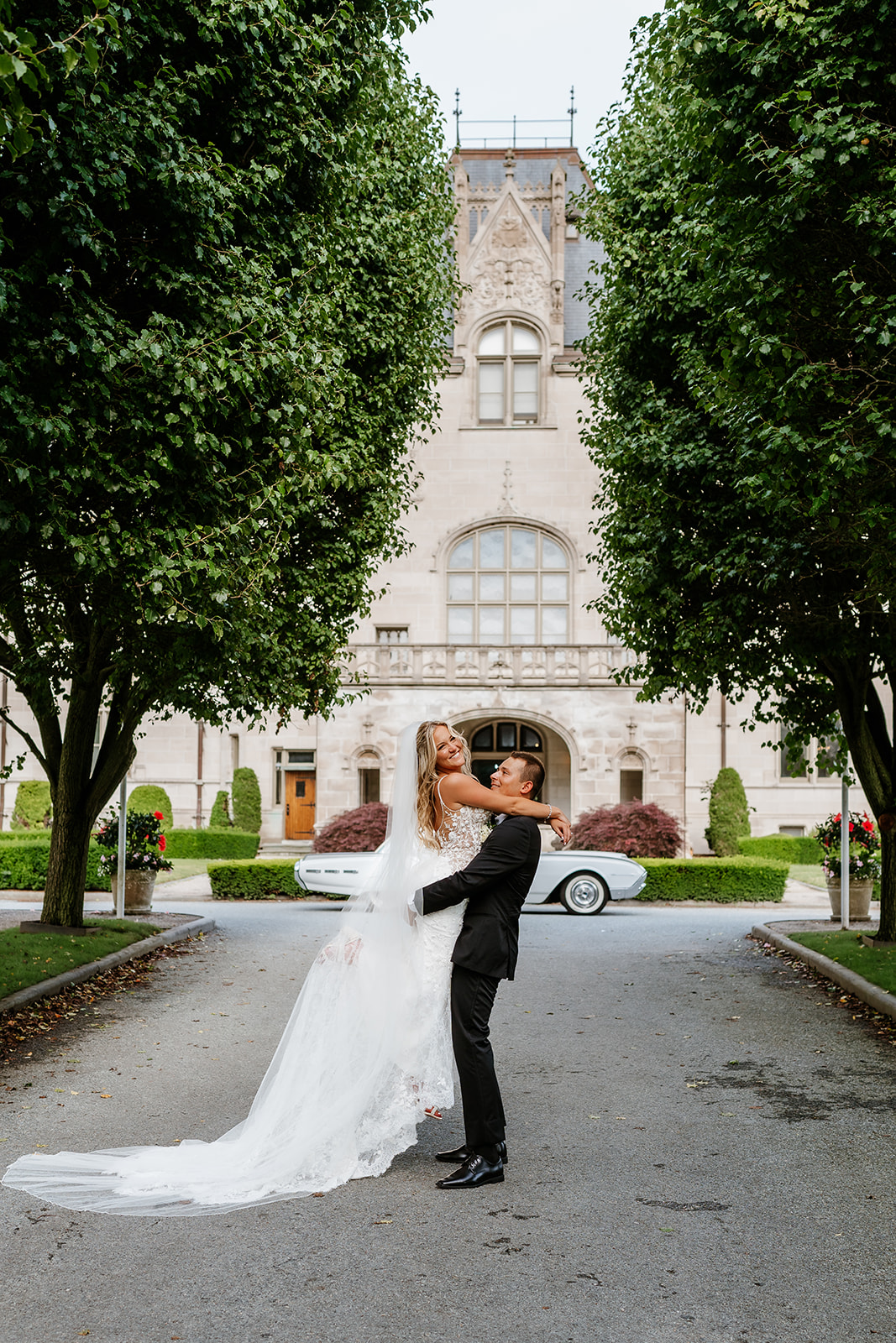 bride and groom fun photo as groom holds bride in front of Ochre Court