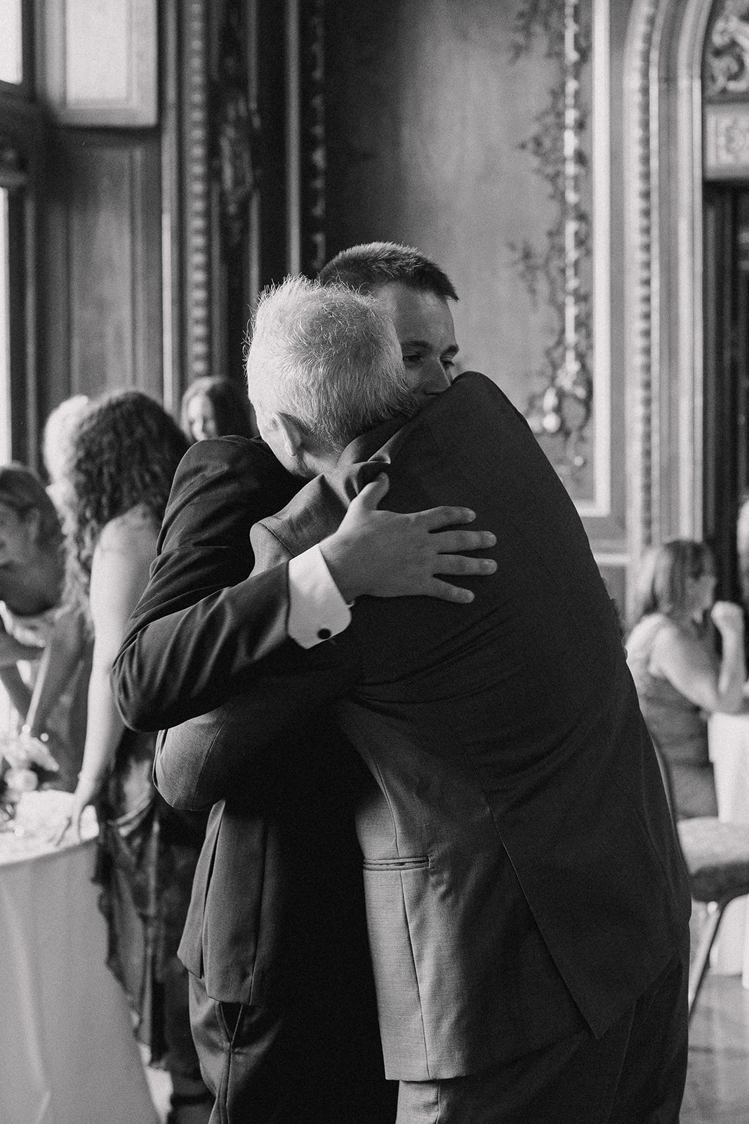 groom hugging father during wedding reception speeches