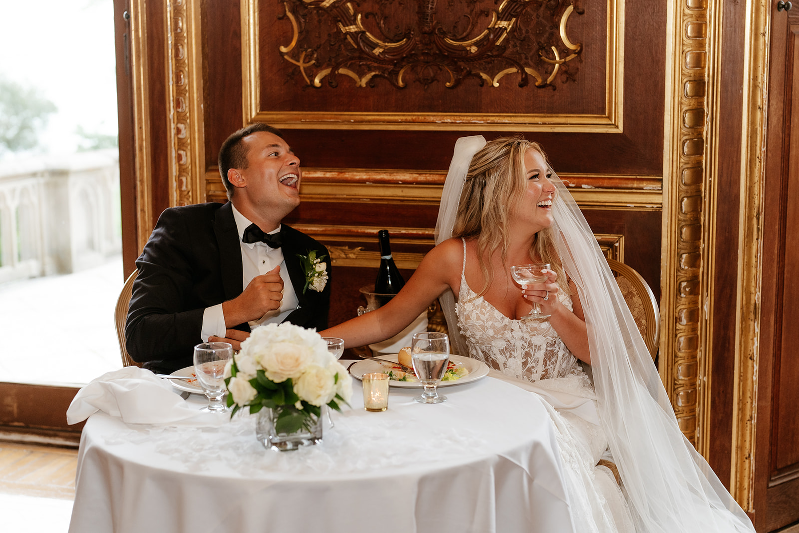 bride an groom laughing during wedding reception speeches