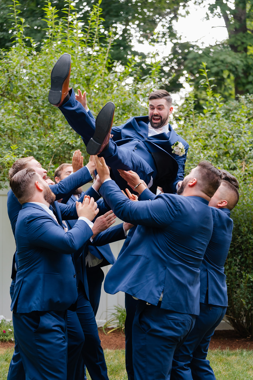 groomsmen throwing the groom up in the air