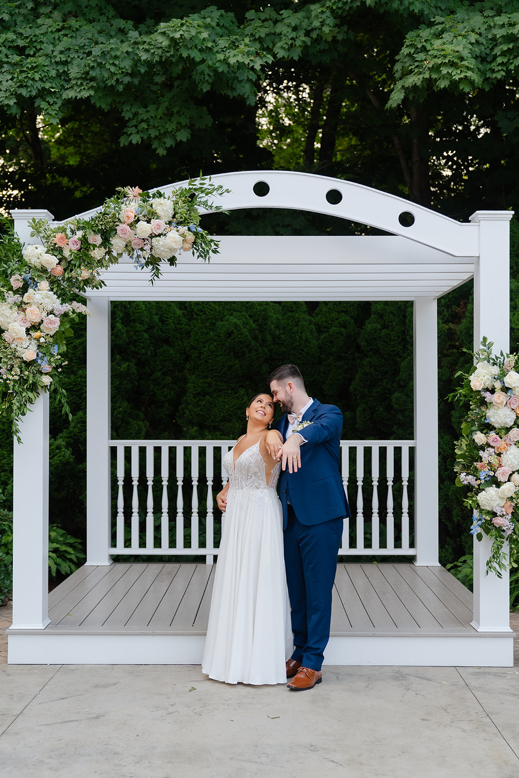 bride and groom standing in the wedding ceremony arch showing off their wedding rings