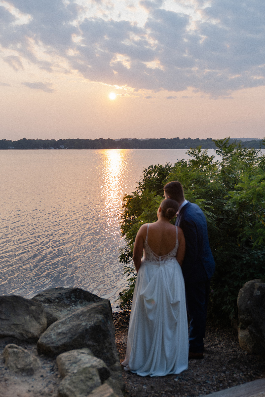 sunset wedding photo of bride and groom near the lake