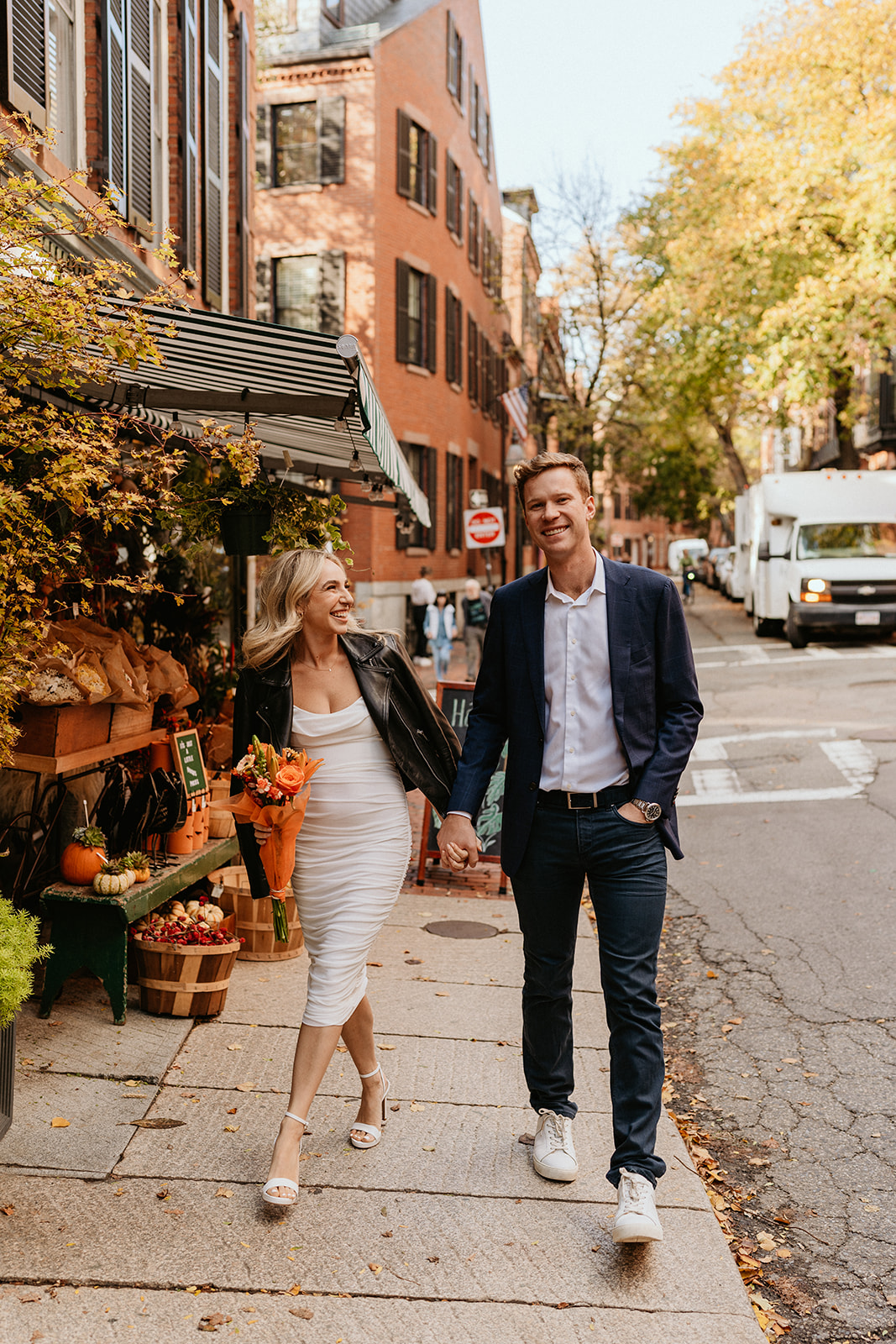 engaged couple walking and dressed classy for their engagement photoshoot in Boston