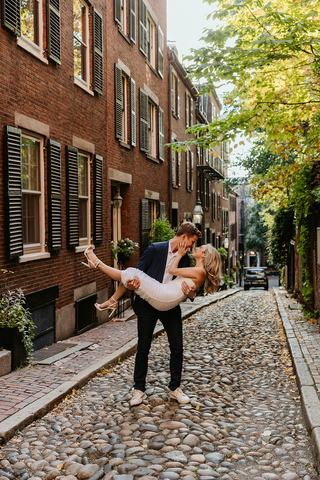 the engaged couple, a man carries his future bride outside 