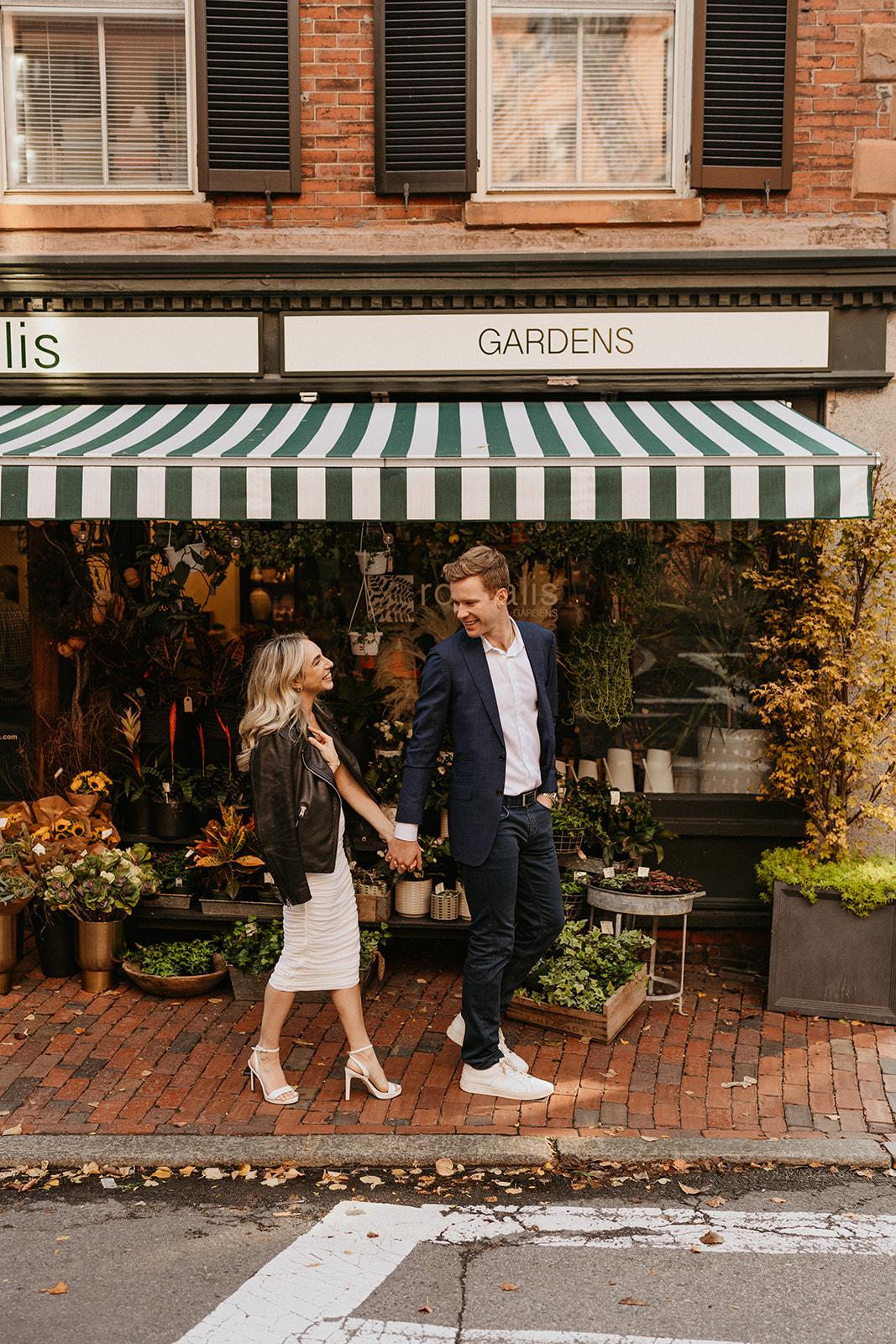 the engaged couple hold hands at the streets of Beacon Hill 