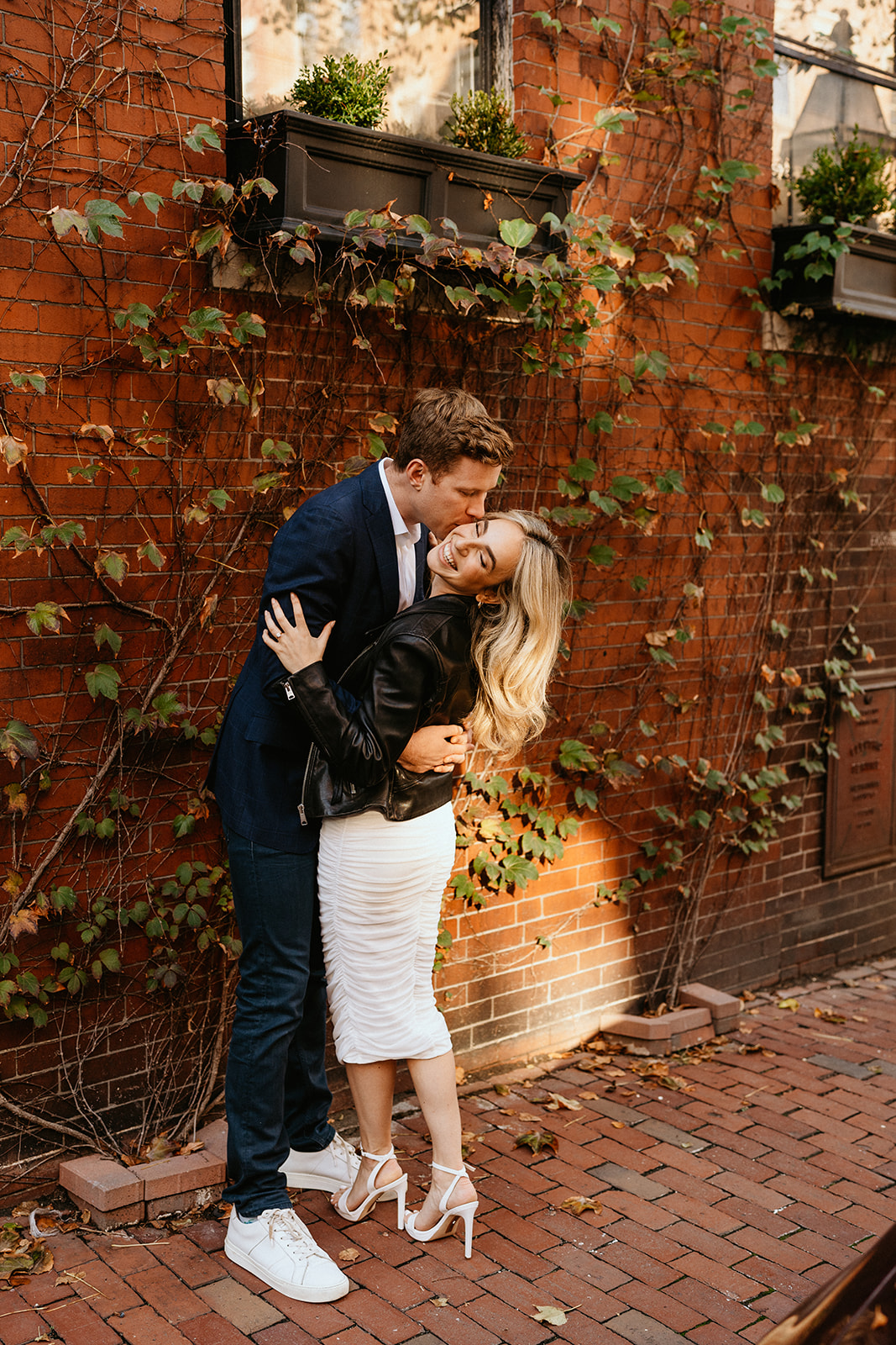 engaged couple hugging and kissing during the autumn season