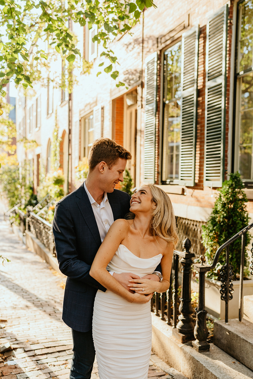 engaged couple posing, looking at each other standing a part of each other boston