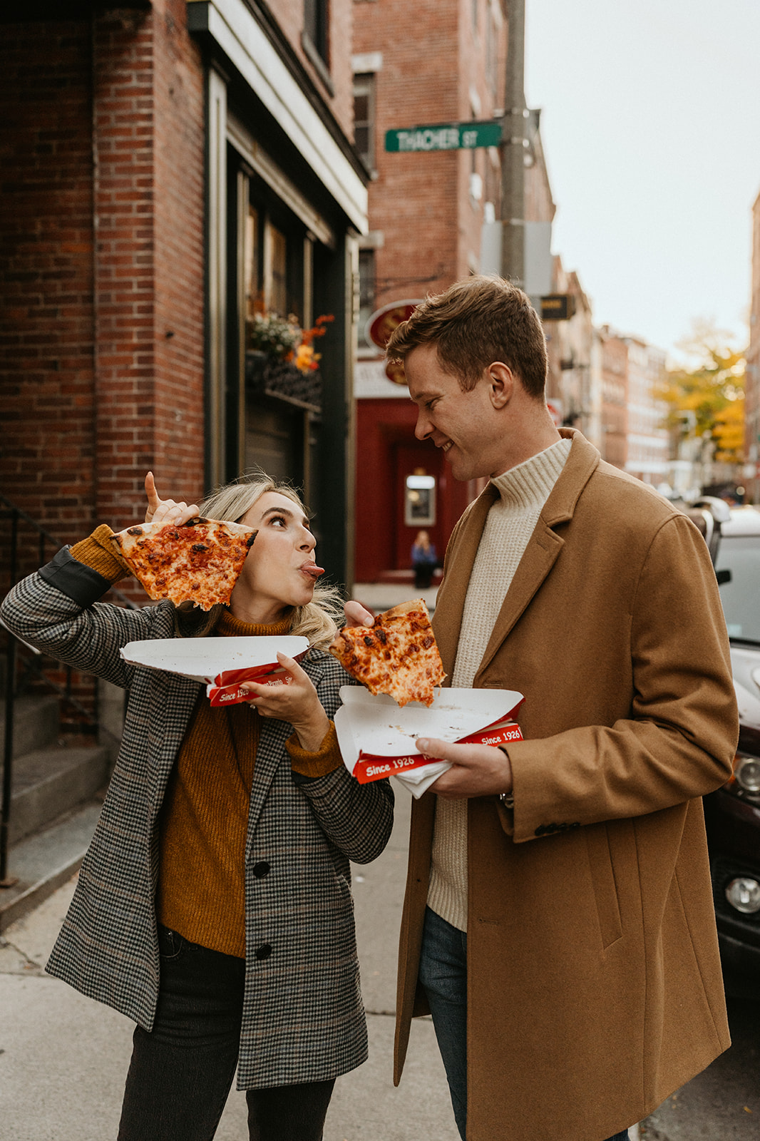 candid photo being fun and silly holding their pizza