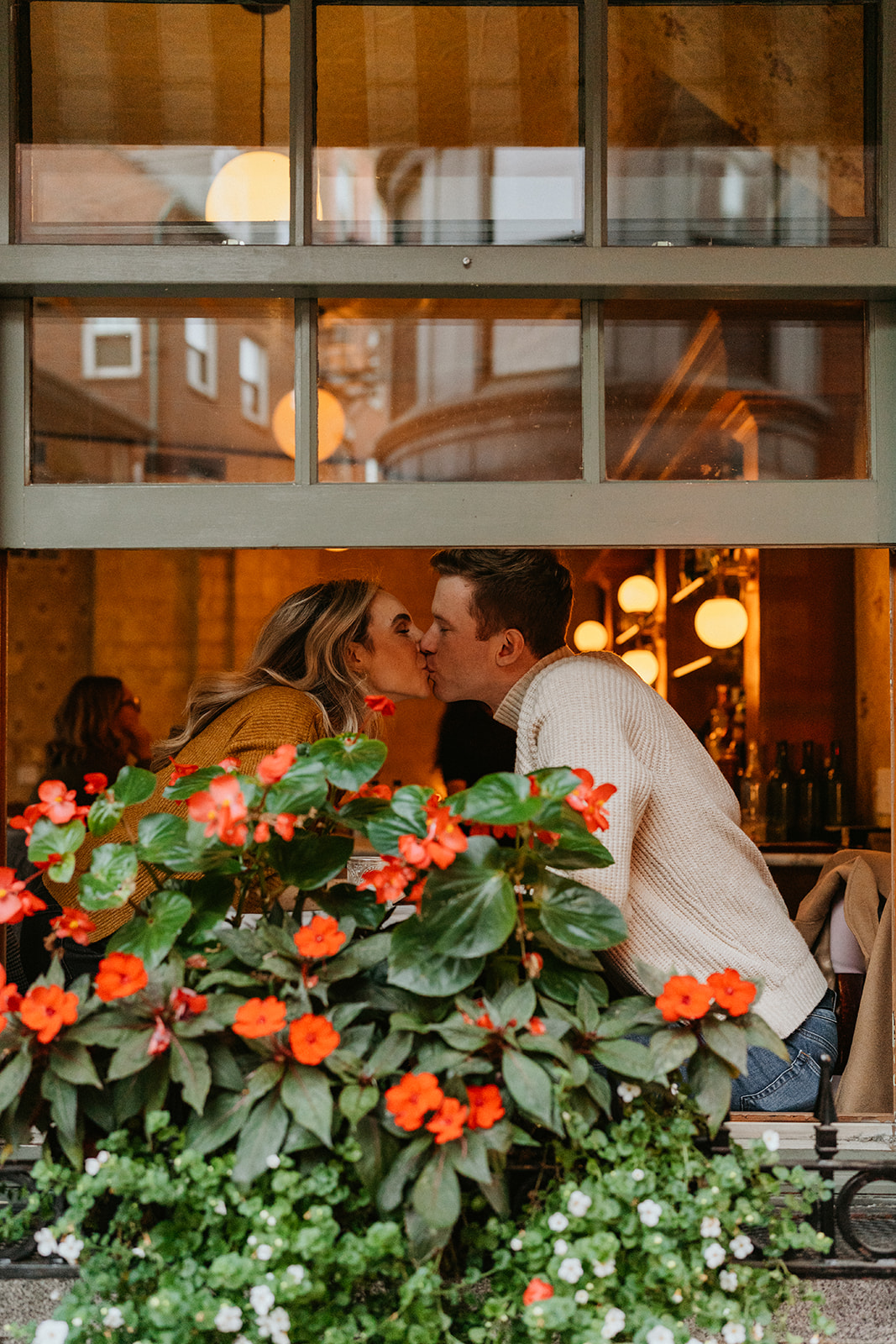 romantic photo of the couple  kissing from a window of a cafe 