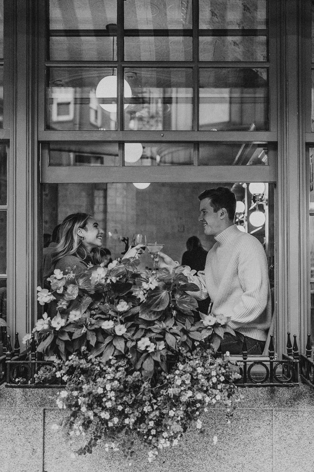 couple smiling and toasting in a cafe