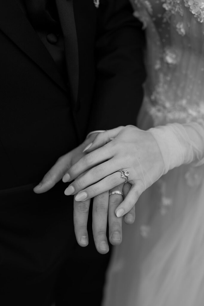 black and white wedding detail photo of the bride's hand on the groom's 