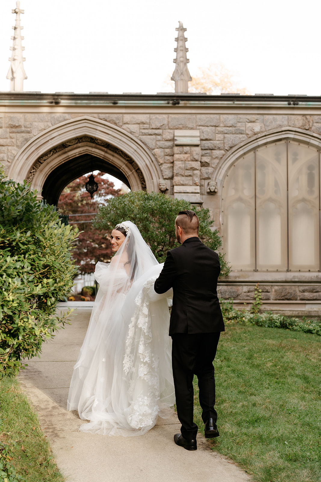 groom holding on to bride's elegant wedding dress